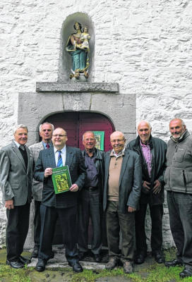 Autor Guido Minninger und der Vorstand des Heimat- und Geschichtsvereins präsentieren vor der Marienkapelle das umfangreiche Werk über dieses geschichtsträchtige Bauwerk.           Foto: Helga Giesen